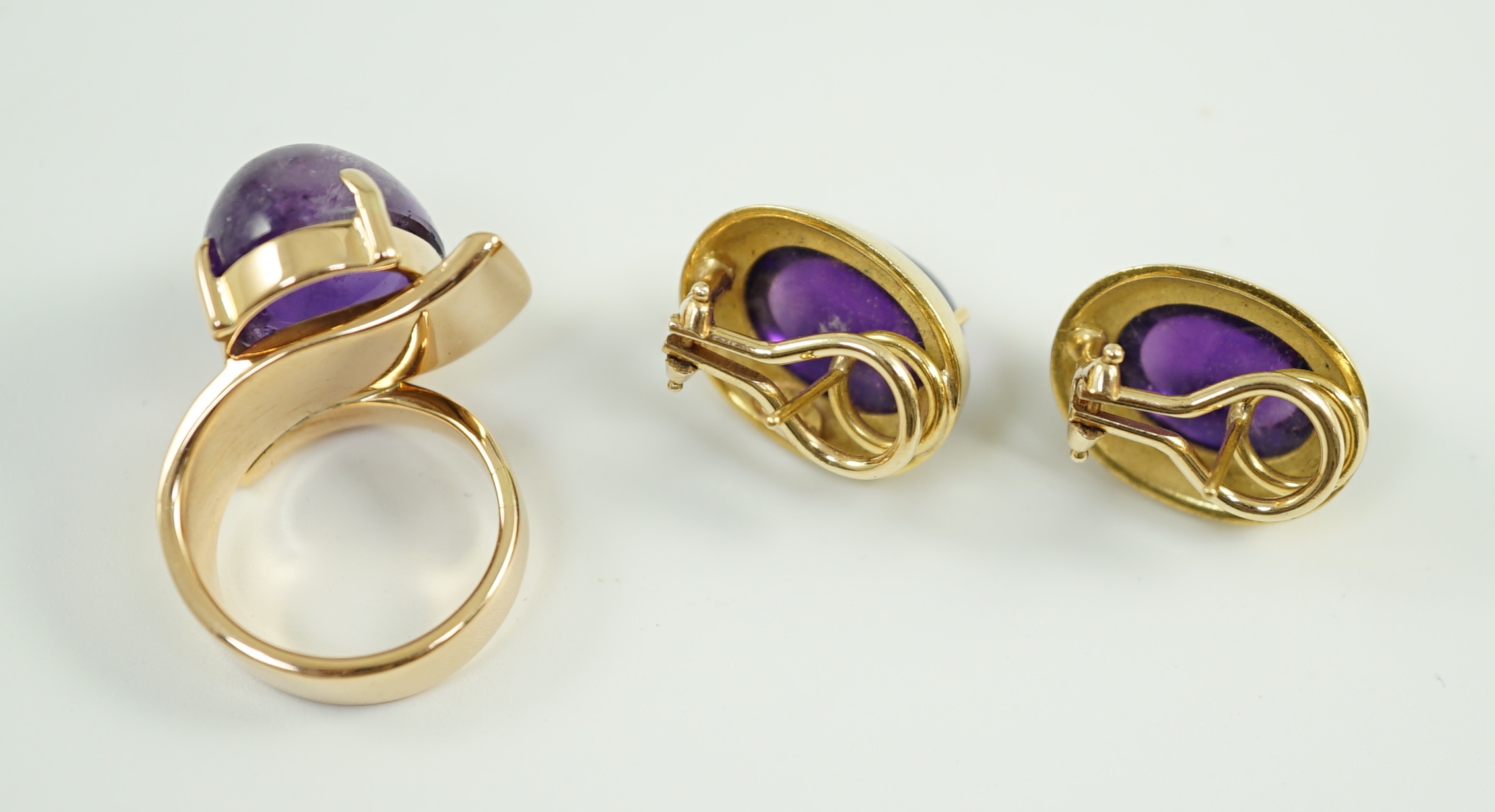 A modern gold and cabochon oval amethyst set dress ring and a pair of similar earrings